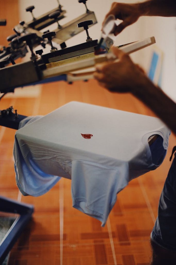 Crafting Captivating Headlines: Your awesome post title goes here Close-up of a man using a T-shirt printing machine indoors.